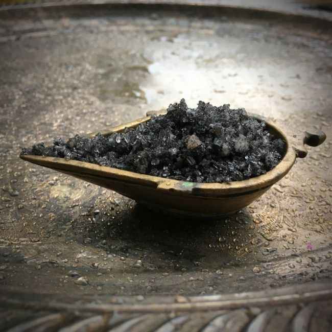 Ritual Aromatics Ritual Ligtning black bath salts in a small brass dish on a silver tray with rain drops 