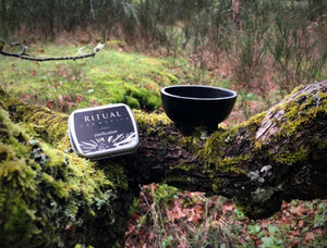 Ritual Aromatics Purification Loose Incense outside on a tree branch with a cast iron cauldron and a mossy background