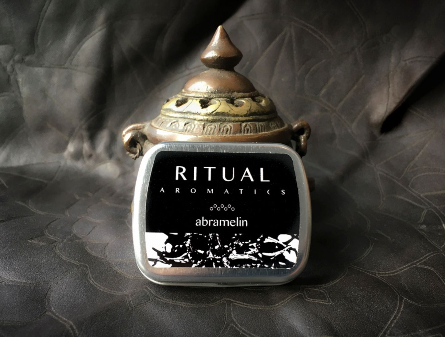 Ritual Aromatics Abramelin Natural Loose Incense on gray leather in front of an antique brass incense burner