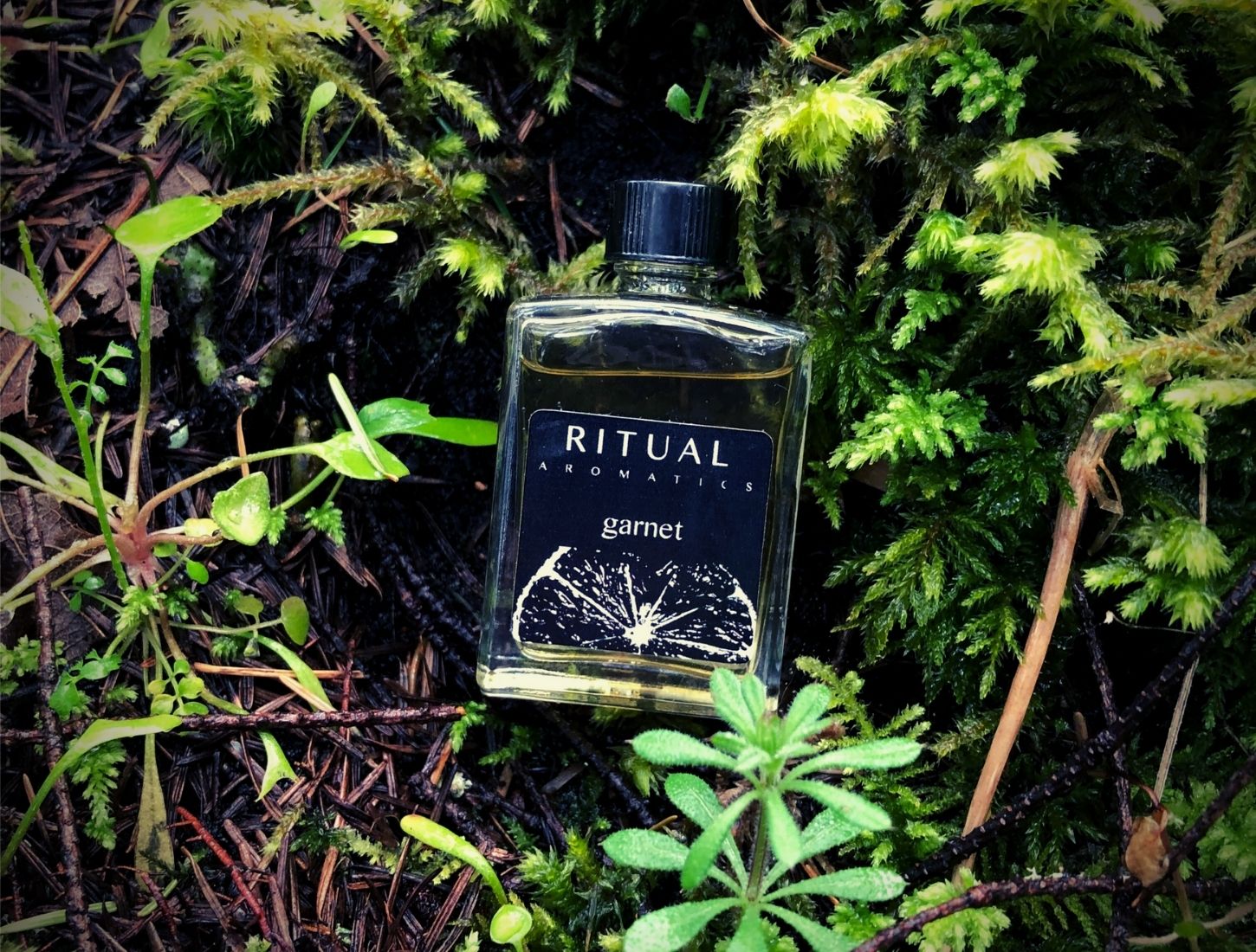 Ritual Aromatics Garnet Natural Perfume 5ml bottle outside in green moss