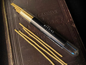An open vial of Ritual Aromatics Tea Ceremony Incense Sticks on an old leather bound book